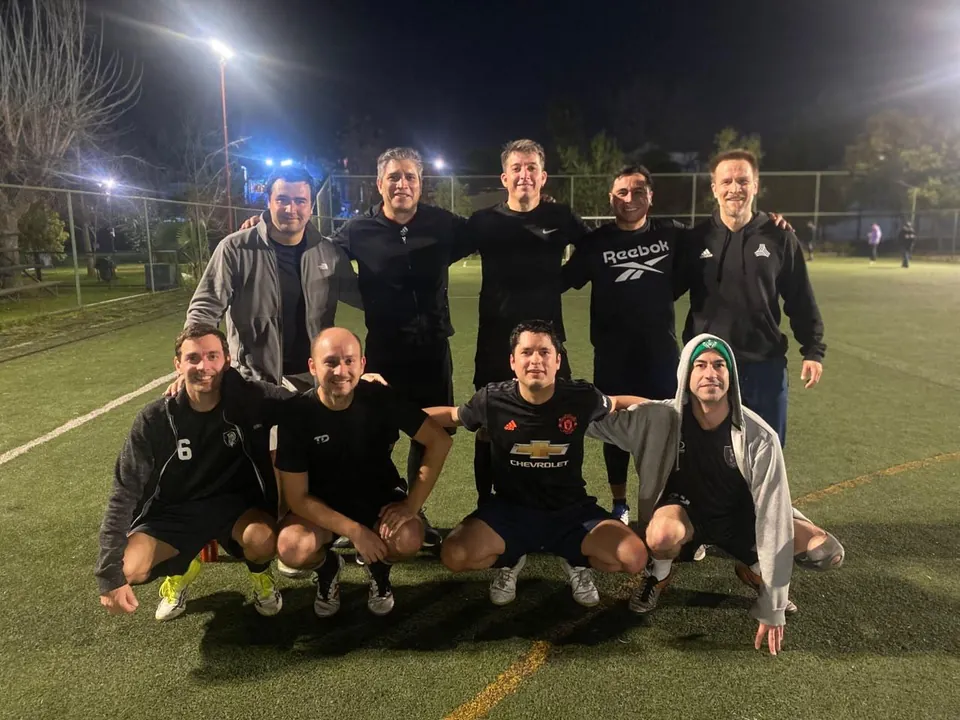 Grupo de adultos de Future Champions en la cancha iluminada de noche
